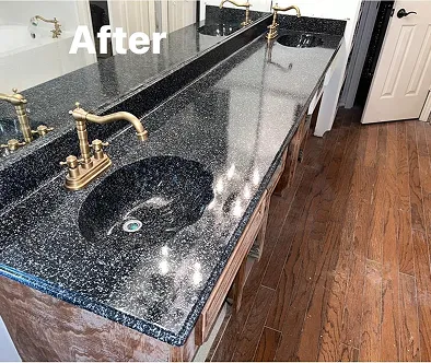 Bathroom vanity with black granite countertop, double sinks, and brass faucets.