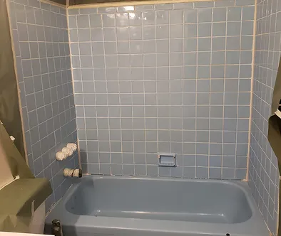 Blue tiled bathtub with shower head and soap dish