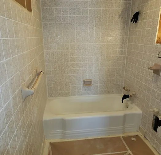Bathroom with tiled walls, bathtub, and shower fixtures.