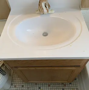 Bathroom vanity with white sink and wooden cabinet