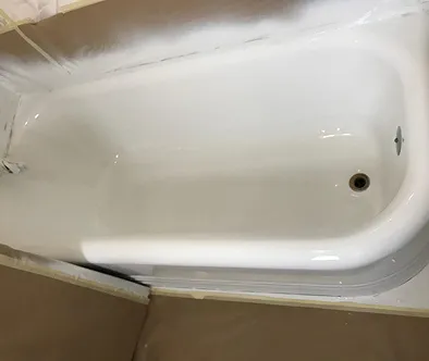 Newly refinished bathtub with protective tape around the edges.