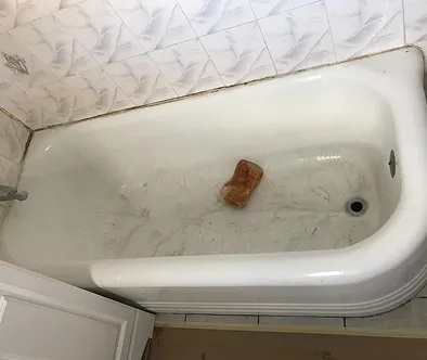 Dirty bathtub with a sponge inside.