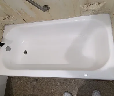 White bathtub with chrome fixtures and a grab bar above.