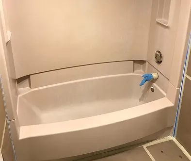 Bathtub with blue glove on faucet